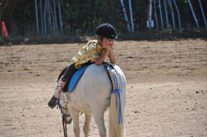 Tüdruk istub tagurpidi hobuse seljas.